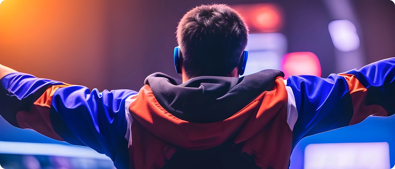Um jogador está no pódio com os braços erguidos após sua vitória em um torneio de esports.